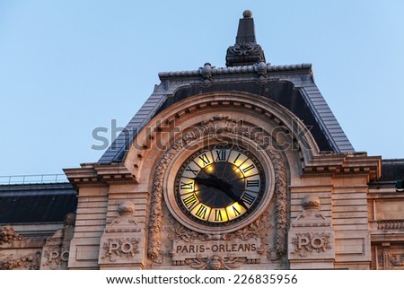 Evening illumination of famous ancient clock on the wall of Orsay Museum in Paris