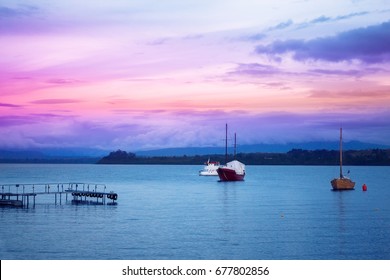 Evening lake Llanquihue with boats and coastline in the distance - Shutterstock ID 677802856