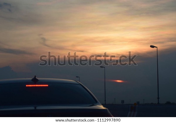 Evening light\
of sunset and the car in the\
street.