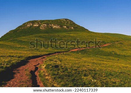 Evening mountain landscape with green hills and rocks under blue sky in Old Mountain National park, nature preserve between Serbia and Bulgaria. Stara Planina hillside on summer day.