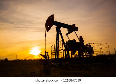 In The Evening, The Outline. The Oil Pump, Industrial Equipment. Field Site, Oil Pumps Are Running. Rocking Machines For Oil Production In A Private Sector.