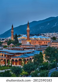 Evening panoramic view of Bursa featuring the historic Grand Mosque (Ulu Cami), traditional city architecture and the slopes of Uludag Mountain under soft twilight light in Bursa, Turkey.