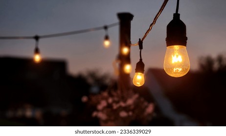 Evening photo of outdoor string lights with depth of field - Powered by Shutterstock