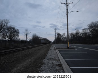 An evening scenery of a street with a railway on the side