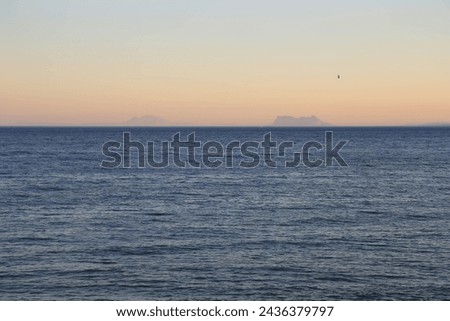 Evening seascape with peach-colored sunset sky and view of mount Gibraltar. Spain. Evening seascape with sunset sky overlooking Gibraltar.