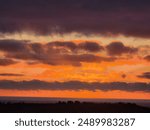 Evening sky with dramatic clouds over the sea. Dramatic sunset with orange clouds. Nature background. A view where the sky and the sea meet. View of the lagoon in Oualidia, Morocco