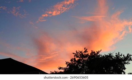 Evening sky glows with reddish clouds and dark tree outlines. Florida, September 18, 2025
