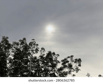 The evening sky, gray clouds obscuring the sun.