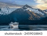 Evening sky over the Alaskan mountain range, boats on the Inside Passage.