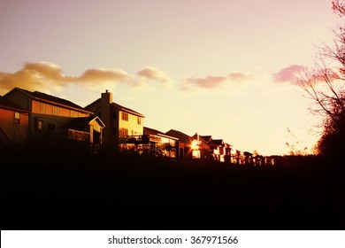 Evening Sun Setting On A Row Of Suburban Houses In A Subdivision