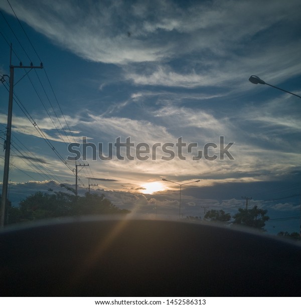 The evening sun shines through the clouds through\
the driver\'s eyes.
