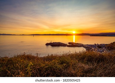 Evening Sunset On Vancouver Island. People Gather To Watch. Harvest Light