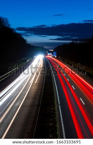 Evening Traffic on German Autobahn (A46) Highway at blue Hour near Hagen and junction to “Sauerlandlinie” (A45) Germany with many white flash and red back light traces, long time exposure in darkness.