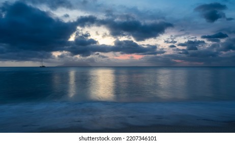 Evening twilight over the Indian Ocean. Blue clouds in the sky, highlighted in pink. Reflection on turquoise water. Foam of waves on the sand of the beach. Long exposure. Seychelles. Mahe. Beau Vallon - Shutterstock ID 2207346101