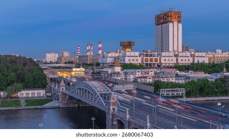 Evening view at the Russian Academy of Sciences day to night transition timelapse and Novoandreevsky Bridge over the Moscow River. Aerial view from rooftop after sunset