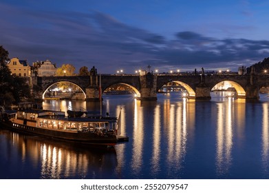 Evening view of the Vltava River with illuminated bridges and a moored boat in Prague - Powered by Shutterstock