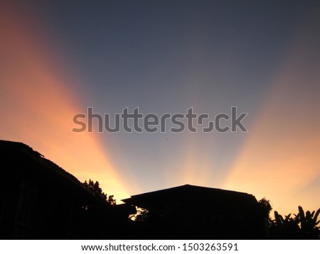 In the evening, when the sun sets, there is orange light in the dark blue sky of a rural village. Phrae Thailand.