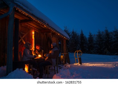 Evening Winter Cottage Friends Enjoy Hot Drinks In Snow Countryside