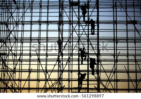 evening, the workers are climbing the silhouette of scaffolding in the high altitude, horizontal and vertical scaffolding formed a myriad of grid, industrial and modern urban construction background.