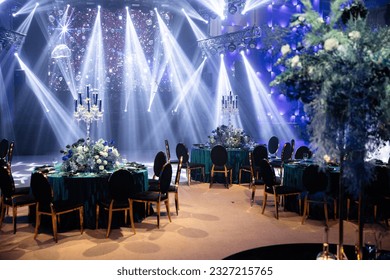 Event decor, table setting, light filling, stage, table, tablecloth, evening, wide angle, horizontal photo.