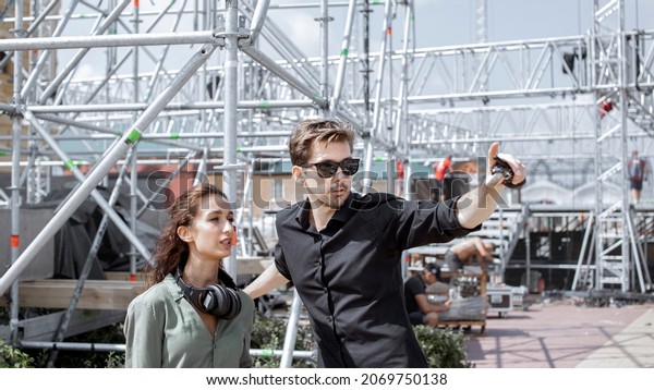 \
Event\
managers discuss stage construction. Installation of stage\
equipment and preparing for a live concert open air. Event manager\
portrait. Summer music city festival.\
Teamwork.