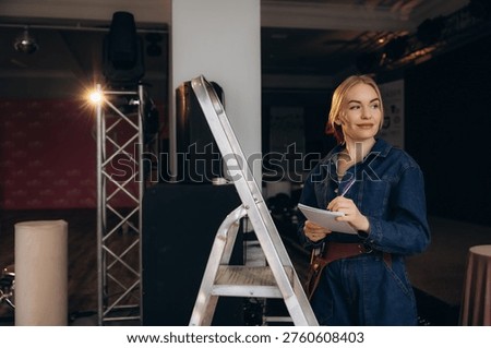 Event planner working on a stage setup, managing production details and writing notes for the upcoming event