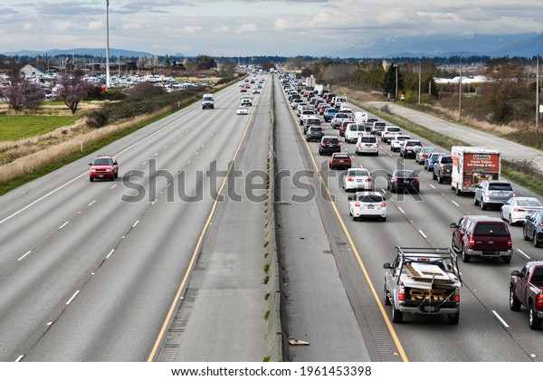 Everett, WA,\
USA - March 15, 2021; Comparison between the commuters in a evening\
traffic jam on their way home and the speeding traffic on the\
opposite commute lanes of Interstate 5\
