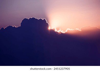 Every cloud has a silver lining. Sun rises over cumulus clouds its light rays breaking cover above the heavens