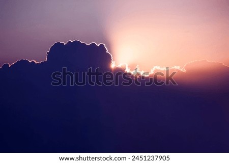 Every cloud has a silver lining. Sun rises over cumulus clouds its light rays breaking cover above the heavens