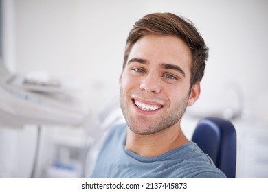 Every dentists favorite patient. Portrait of a young, smiling man sitting in a dentists chair. - Powered by Shutterstock