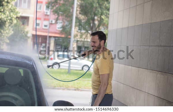 Every job
is done with a smile. Man washing his
car.