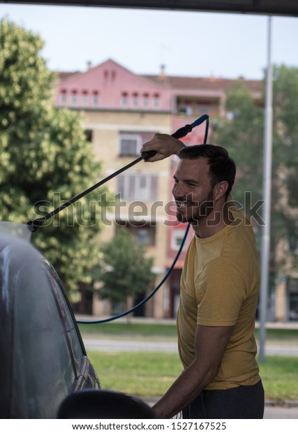 Every job\
is done with a smile. Man washing his\
car.