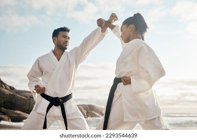 Every move has a counter. Cropped shot of two young martial artists practicing karate on the beach. - Powered by Shutterstock