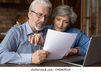 Every Paper Needs Attention. Interested Old Age Married Couple Do Paperwork Engaged In Reading Document. Focused Retired Spouses Study Terms Conditions Of Insurance Policy Think On Signing Agreement