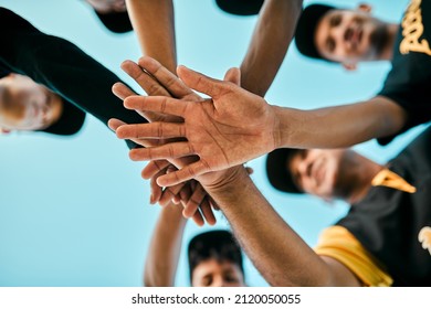 Every player plays a large role. Shot of a team of young baseball players joining their hands together in a huddle during a game. - Shutterstock ID 2120050055