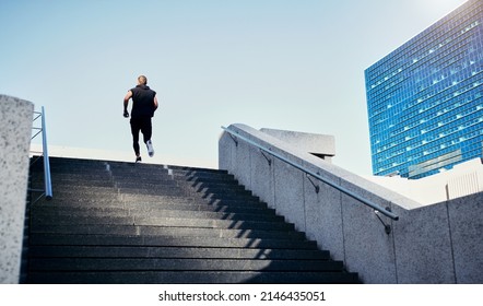 Every Step Is One Step Closer To Your Goal. Rearview Shot Of A Young Man Running Up Stairs In The City.