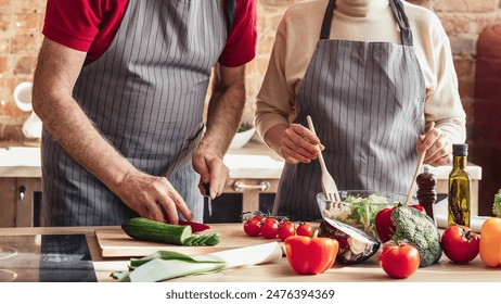 Everyday life. Lovely senior couple wearing aprons cooking together on modern kitchen at home, cropped shot - Powered by Shutterstock