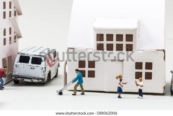 Everyday life, miniature family in front of a house\
in a town