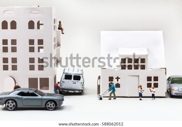 Everyday life, miniature family in front of a house\
in a town