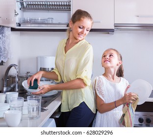 Everyday routine: happy russian girls doing and wiping dishes in kitchen - Powered by Shutterstock