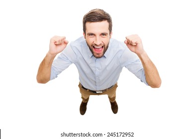 Everyday winner. Top view of happy young man expressing positivity and gesturing while standing isolated on white background