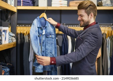 Everyone Needs A Classic Denim Jacket In Their Closet. Shot Of A Young Man Looking At Clothes In A Boutique.