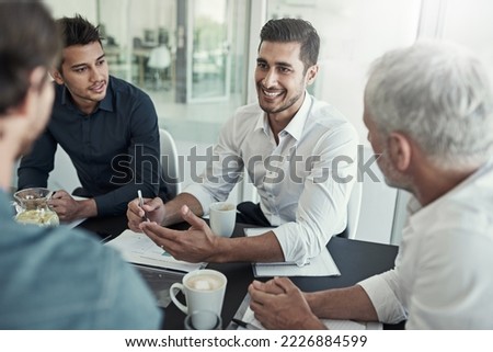 Everyones feeling positive about this meeting. Shot of a group of businessmen having a meeting around a table in an office.