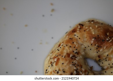 Everything Bagel On White Plate Scattered Seasoning Bottom Right Corner Close Up