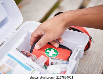 Everything he needs to treat your injuries. High angle shot of an unrecognizable male paramedic looking in his first aid kit while standing outside. - Shutterstock ID 2167864911