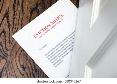 EVICTION NOTICE ON HARDWOOD FLOOR SLIPPED UNDER ENTRANCE DOOR - Shutterstock ID 580348267