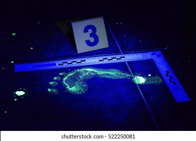 Evidence Of Footprint On Place Of Crime In Bathroom Under UV Black Light