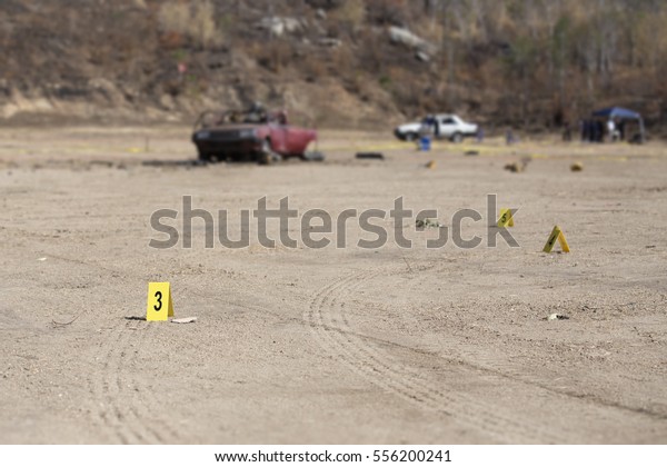 evidence marker and blurred wrecked car with law\
enforcement background in post blast investigation training with\
copy space
