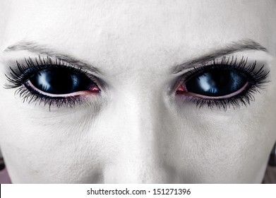 Evil black female alien, vampire or zombie eyes. dirt make up. Macro. Halloween theme 