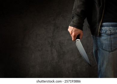Evil criminal with large sharp knife ready for robbery or to commit a homicide